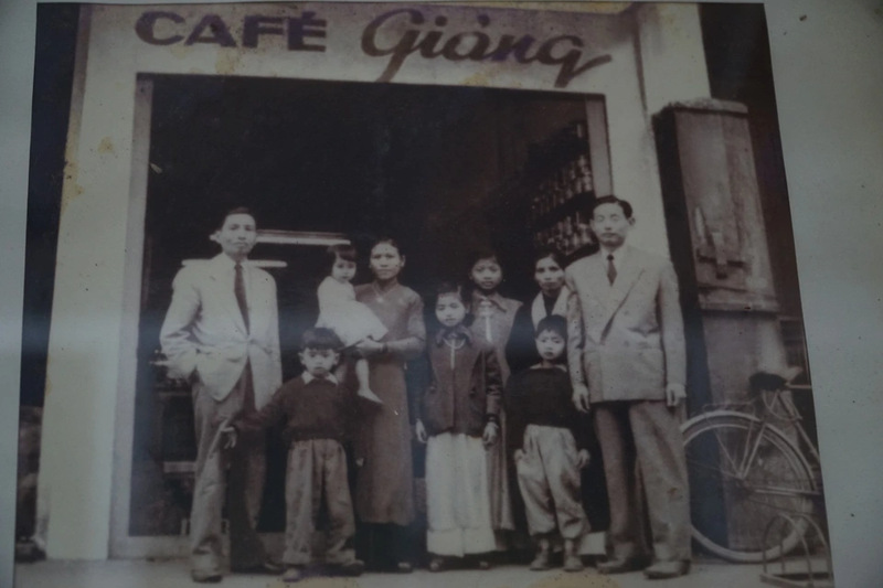 Historical photo of Mr. Nguyen Van Giang and his family standing in front of the original Cafe Giang in Hanoi, the birthplace of Vietnamese Egg Coffee.