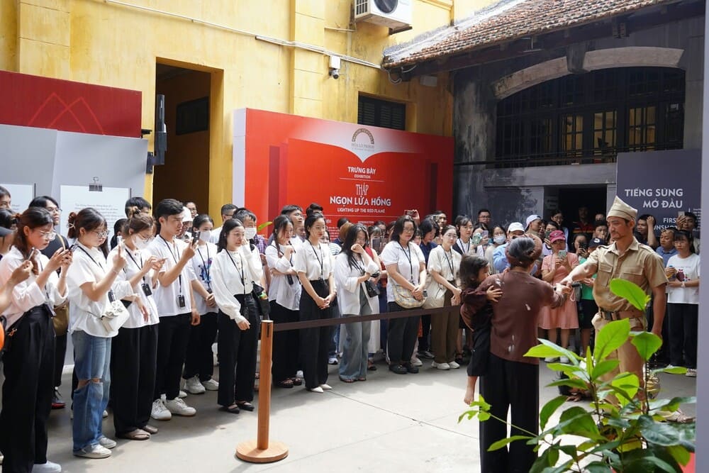 Visitors exploring Hoa Lo Prison respectfully, a site considered sacred in Vietnamese history.