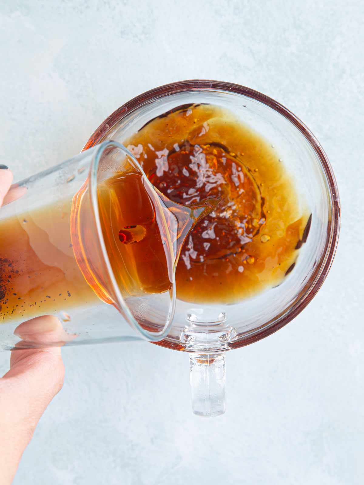 Pouring strong brewed Local Beans Roastery Robusta coffee concentrate into a glass to prepare Cà Phê Muối