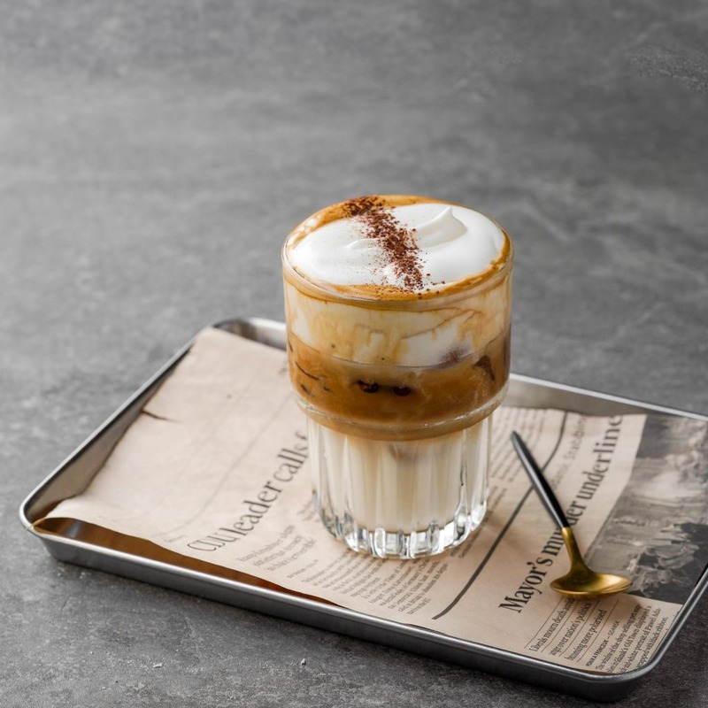 A glass of authentic Salt Coffee Vietnam (Cà Phê Muối) with a thick layer of salted foam on top of dark Robusta coffee by Local Beans Roastery.